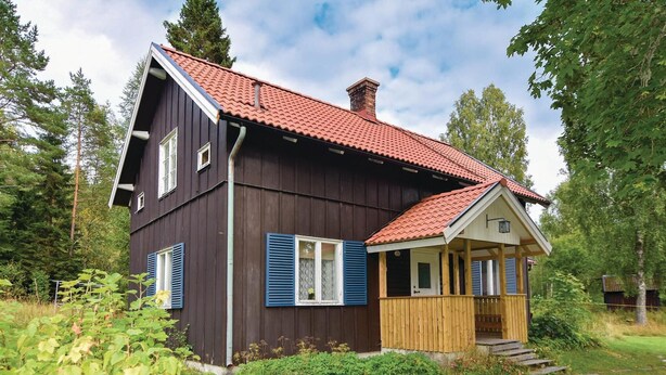 A two-story house with a red-tiled roof, a wooden porch, and a chimney. - 3 bEdroom pet friendly home in Ed (Ed)