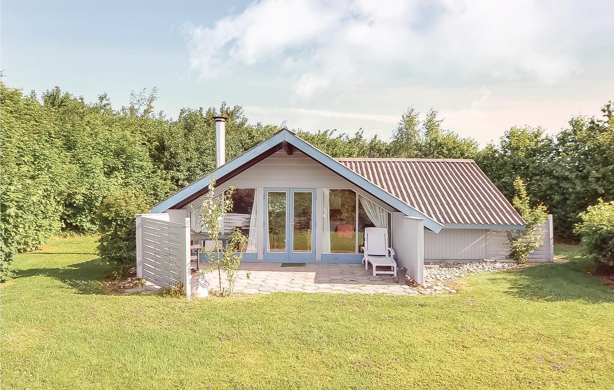 A small, single-story house with a sloped roof and a large sliding glass door entrance.