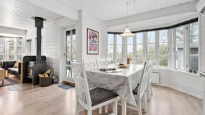 A modern kitchen with a built-in stove, white cabinetry, and large windows offering views of the outdoors. - Amazing home in Tarm with sauna (Tarm)