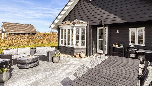 A deck with outdoor furniture, a grill, and a windowed porch area. - Amazing home in Tarm with sauna (Tarm)