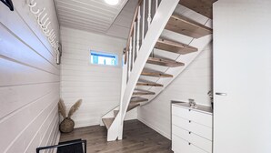 A staircase with wooden steps and white railings leading to a landing. - Amazing home in Tarm with sauna (Tarm)