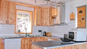 A kitchen with wooden cabinets, a window, a microwave, and a sink. - 5 bedroom gorgeous home in Sälen (Sälen)