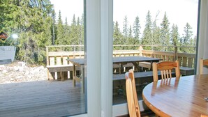 A wooden deck with picnic tables and chairs, overlooking a forested area. - 5 bedroom gorgeous home in Sälen (Sälen)