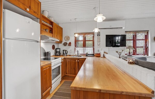 Enjoy cooking in this well-equipped kitchen with a central island, sink, and oven, plus a large window offering a view of the surrounding area.