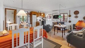 A cozy living room with a dining area, wooden furniture, and a television. - 2 bedroom lovely home in Broager (Broager)