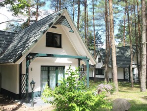Ein Gebäude im traditionellen Stil mit einem geneigten Dach, einem Hauseingang und einer kleinen Veranda.