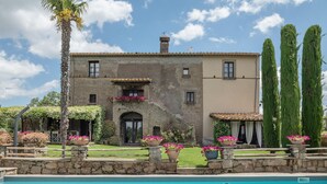 Un edifici de dues plantes amb una piscina al davant.