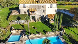 Edifici de pedra de dos pisos amb piscina i un jardí ben cuidat.