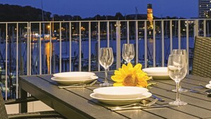 A table set for dining with a view of a marina and a lighthouse in the background. - Priwallpromenade 23, Whg 10 (Travemünde Waterfront)