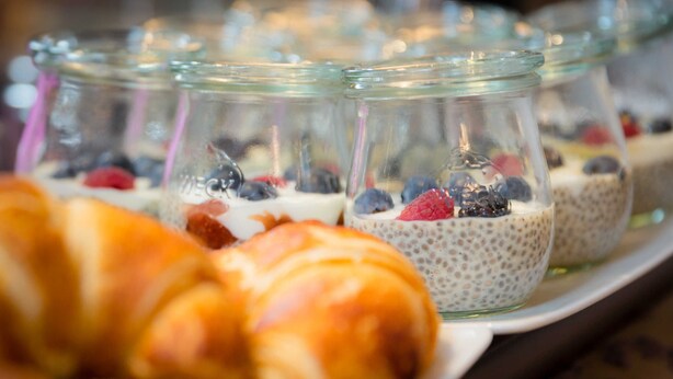 Eine Auswahl an Speisen, darunter Joghurt mit Beeren und ein Croissant.