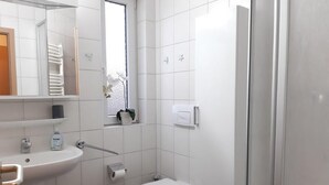 A small bathroom with a sink, toilet, and a mirror. - (274) 1-room apartment - apartment complex Yachthafenresidenz (Kühlungsborn)