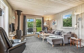 Relax in this stylish living room with a comfortable sofa, armchair, and flat-screen TV.