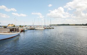 Boats docked at the marina, surrounded by lush greenery and distant buildings.