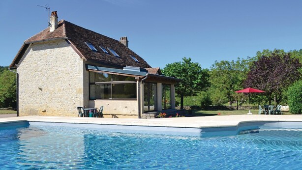 A stone building with a swimming pool, a covered patio, and a red umbrella. - Gorgeous home in Padirac (Padirac)