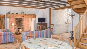 A cozy room with a brick fireplace, wooden furniture, and a tiled floor. - Gorgeous home in Padirac (Padirac)