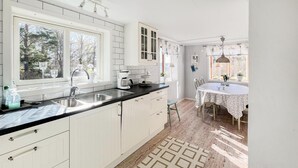 A modern kitchen with white cabinetry, a black countertop, and a patterned rug. - Amazing home in Köpmannebro with WiFi (Köpmannebro)