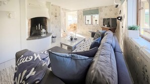 A cozy living area with a sofa, a fireplace, and a television. - Amazing home in Köpmannebro with WiFi (Köpmannebro)