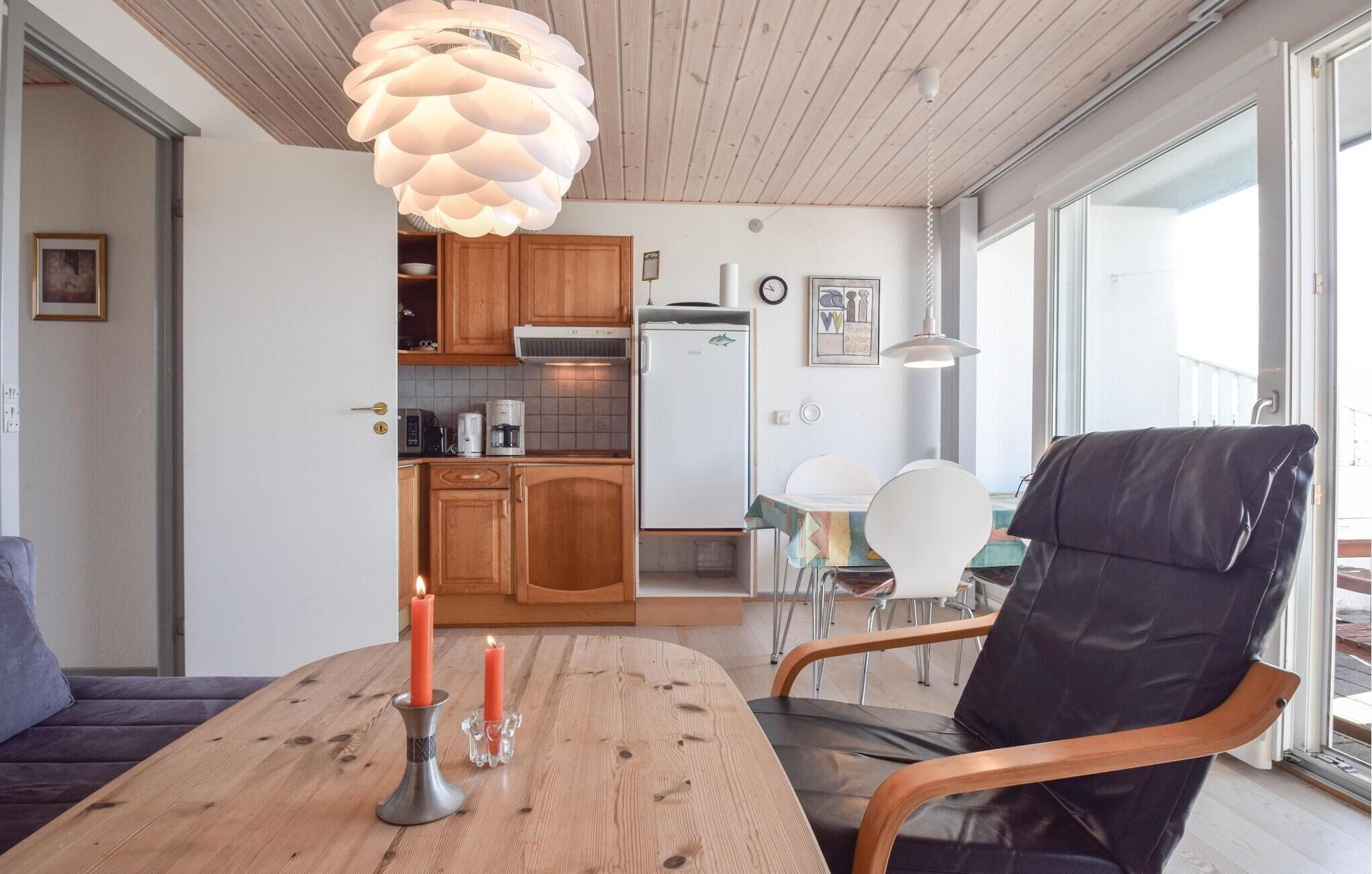 Una cocina moderna con armarios de madera, un refrigerador blanco y un comedor con mesa y sillas de madera.
