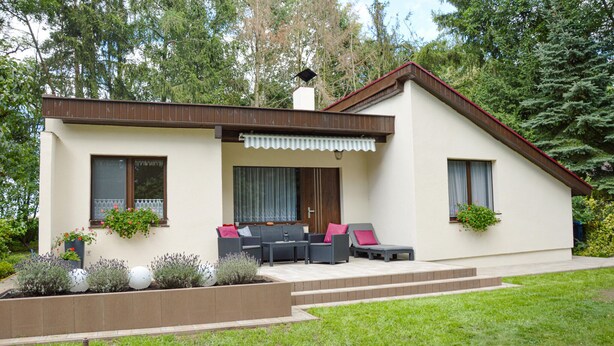 A modern two-story house with a patio area featuring outdoor furniture and potted plants. - Cozy home in Biskupice with WiFi (Biskupice)