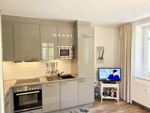 A modern kitchen with stainless steel appliances, a built-in microwave, and a window with curtains. - P: Villa Strandmuschel Whg. 05 - approx. 100m from the beach - Villa Strandmuschel (Sellin)