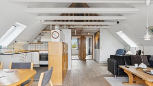 Un appartement moderne de style « loft » comprenant une cuisine, un coin repas et un espace de vie.