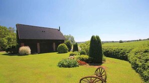 A rustic barn with a sloped roof, surrounded by well-maintained grass and a variety of shrubs. - Holiday home with outdoor pool and Western-style restaurant (Vlcice)