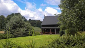 A house with a dark roof, surrounded by lush greenery and trees. - Holiday home with outdoor pool and Western-style restaurant (Vlcice)