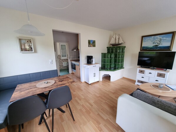 Un espace de vie compact comprenant un coin repas, une kitchenette et un espace détente.