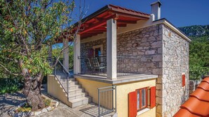 A stone house with a balcony, a staircase, and a view of the surrounding landscape. - Gorgeous home in Barci (Barci)