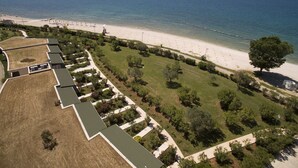 An aerial view of a coastal hotel with a beach, green lawns, and a clear view of the sea. - Victoria Mobilehome Bi Village (Fazana)