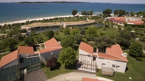 A coastal property with multiple buildings, a beach, and a marina. - Victoria Mobilehome Bi Village (Fazana)