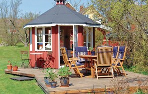 A wooden deck with a gazebo-style structure, outdoor seating, and potted plants. - Awesome home in Sölvesborg with kitchen (Sölvesborg)