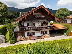 A traditional chalet with a wooden facade, balconies with flower boxes, and a sign indicating 'Steinbeissner'.