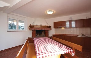 Eine Küche mit Kamin, einer Holzbank und einer karierten Tischdecke.