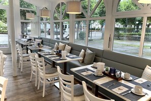 A restaurant with outdoor seating, tables with placemats, and hanging lamps. - Holiday apartment Granitz (A) - Apartment house "Haus Arkona" (Sellin)