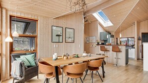 Ein gemütliches Holzinterieur mit Essbereich, Küche und einem großen Fenster mit Aussicht.