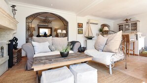 A cozy living room with a sofa, armchairs, a wooden coffee table, and a fireplace. - Cozy home in Les Adrets d l'Estérel (Les Adrets d l'Estérel)
