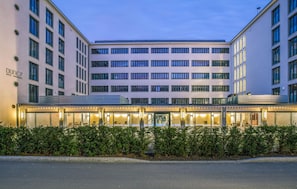 A modern hotel with a flat facade, multiple floors, and a well-lit entrance.
