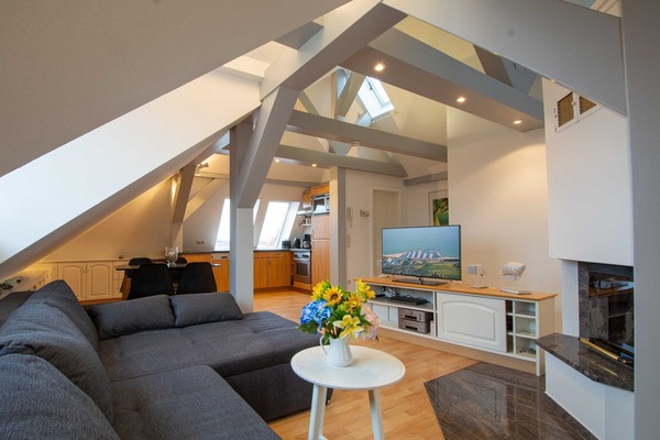 Der helle offene Wohnraum mit gemütlicher Sitzecke und Kamin