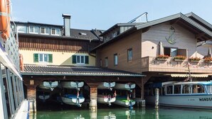 Ein Boot liegt in einer Marina vor einem Gebäude mit einem Balkon und Blumenkästen.