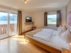 Ein Schlafzimmer mit Bett, Fernseher, Meerblick und Balkon.