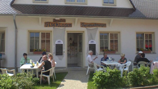A building with a sign reading "BrauB's Fischladen" and "Ferienwohnungen". - Holiday apartment on Blankensee (Trebbin)