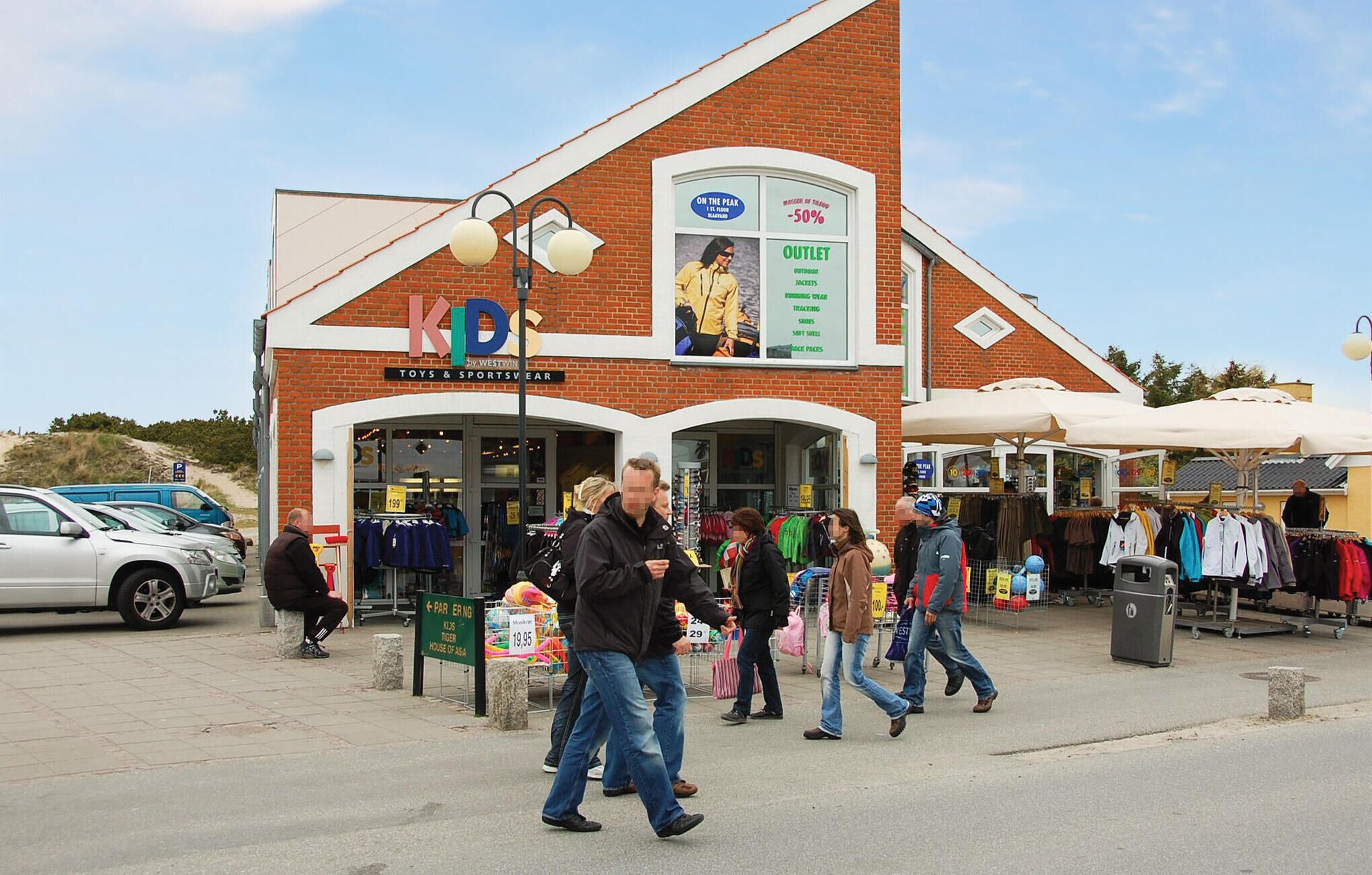 A brick building with a sign reading "KIDS TOYS & SPORTSWEAR".