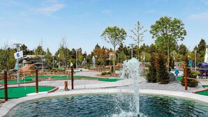 Un campo de mini golf con una fuente de agua.