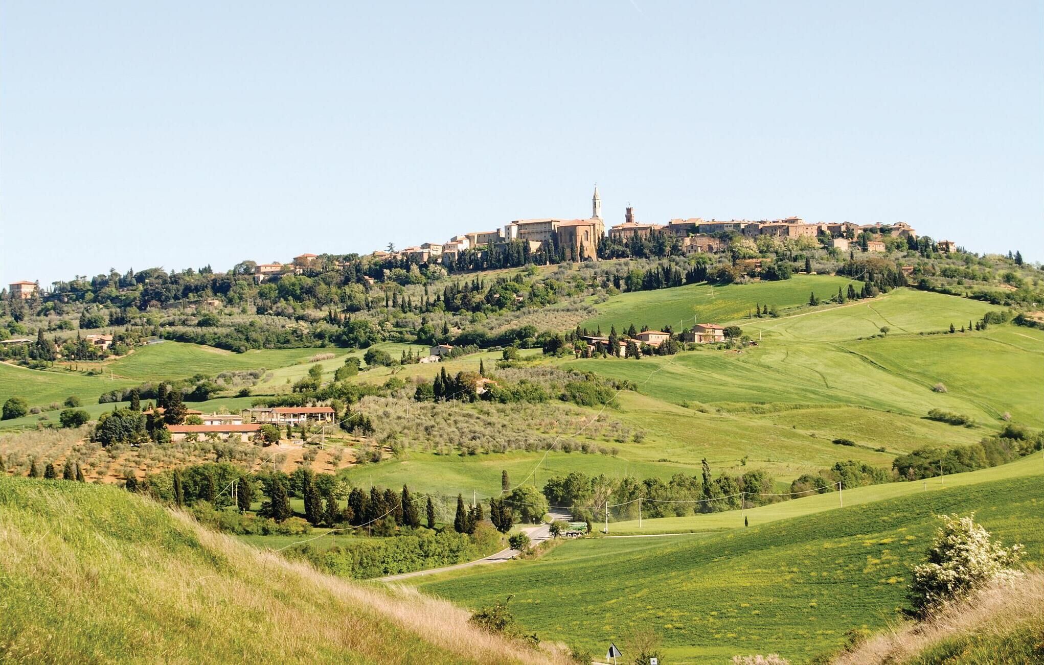 Un paysage rural avec un village perché sur une colline, caractérisé par une architecture traditionnelle, notamment une tour imposante.