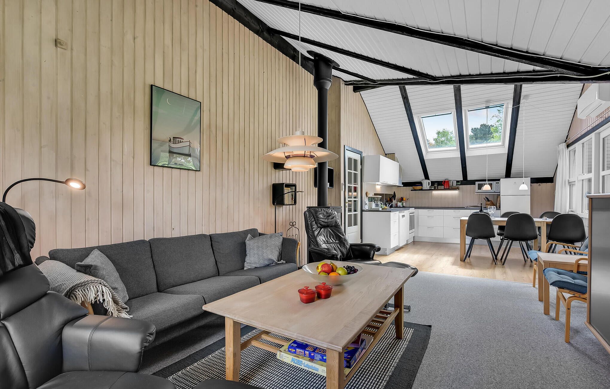 Ein modernes Wohnzimmer mit Sofa, Couchtisch und Essbereich.