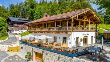 Ein Chalet mit Balkon, Sitzgelegenheiten im Freien und einer Steinfassade.