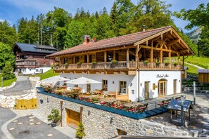 A chalet-style building with a balcony, outdoor seating, and a stone facade. - Family room with 2 bedrooms Berghotel Sudelfeld - Berghotel Sudelfeld (Bayrischzell)
