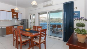 Une cuisine moderne avec un coin repas, de grandes fenêtres et une vue sur la mer.