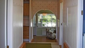 A hallway with patterned wallpaper, a green carpet, and a view of a dining area with a table and chairs. - Nice home in Lenhovda with WiFi (Lenhovda)